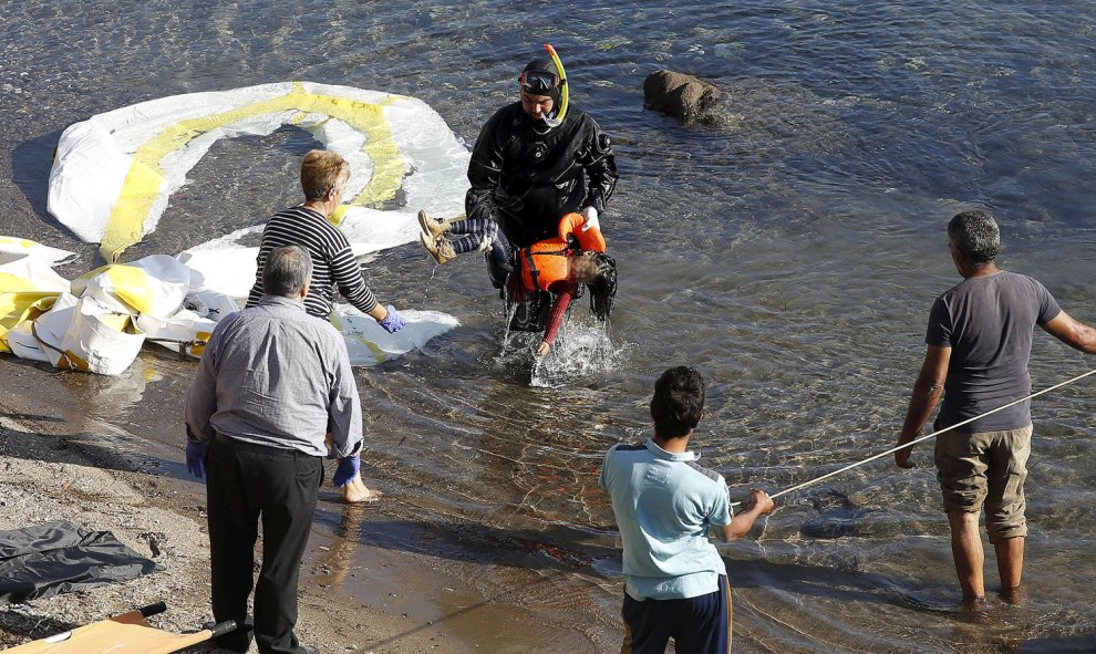 Un guardacostas griego saca del agua el cadáver de un niño refugiado en la costa griega de Lesbos. REUTERS/GIORGOS MOUTAFIS