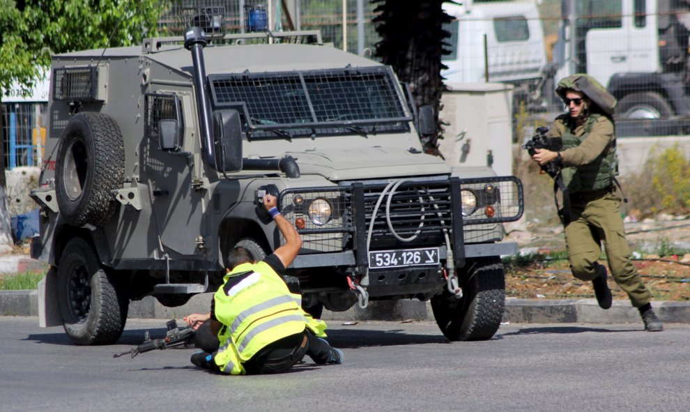 Un atacante palestino, vestido de periodista, apuñala a ua soldado israelí antes de caer fulminado por los disparos del Ejército hebreo cerca de la ciudad de Hebrón, en Cisjordania.- REUTERS / Jameel Salhab