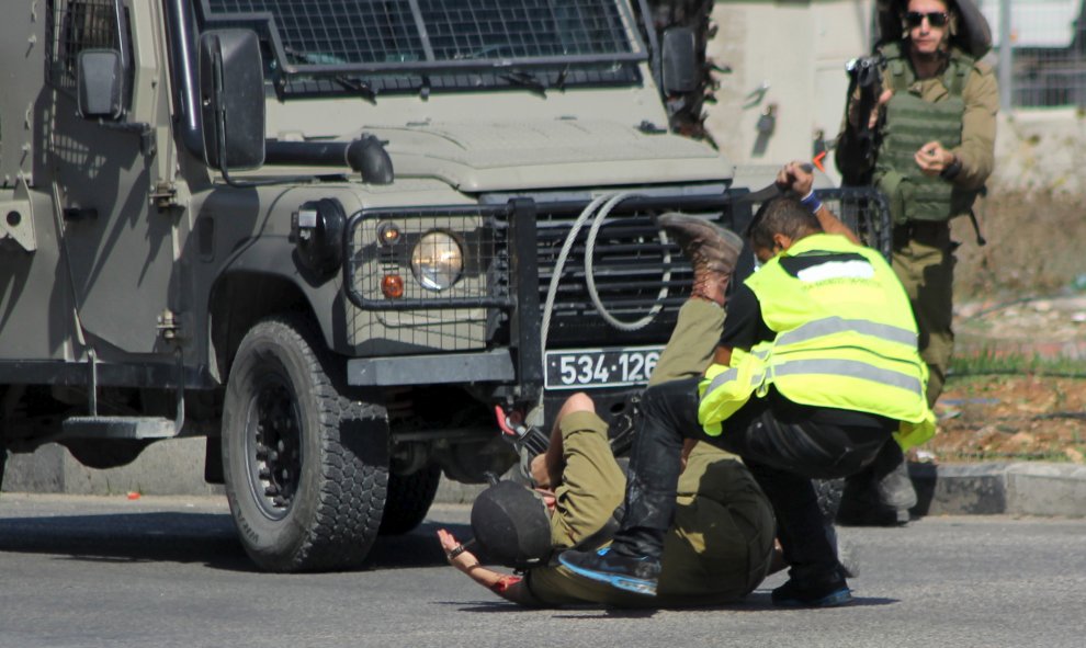 Un atacante palestino, vestido de periodista, apuñala a un soldado israelí antes de caer fulminado por los disparos del Ejército hebreo cerca de la ciudad de Hebrón, en Cisjordania.- REUTERS / Jameel Salhab