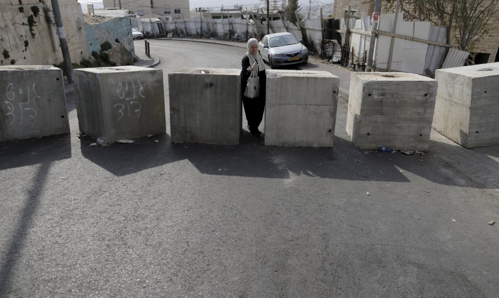 Una mujer pasa entre los bloques de hormigón que fueron colocadas por la policía israelí la semana pasada, en el barrio de Jabel Mukaber. Jerusalén, 19 de octubre de 2015. REUTERS / Ammar Awad