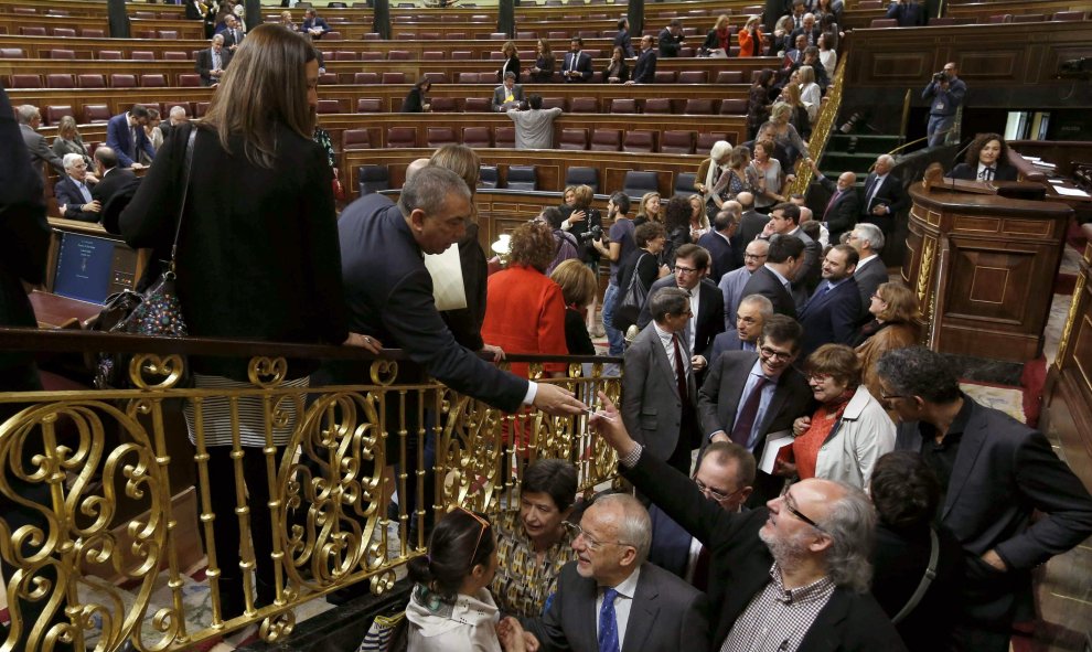 Varios diputados se saludan al término de la última sesión de control al Gobierno con la que la Cámara Baja ha puesto fin a la X legislatura. EFE