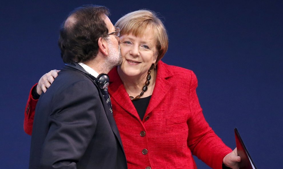 El presidente de España, Mariano Rajoy, besa a la canciller alemana, Angela Merkel en el congreso del Partido Popular Europeo (PPE) en Madrid, España. REUTERS / Juan Medina
