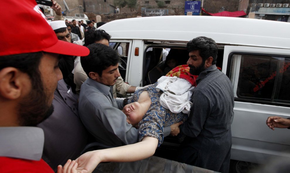 Paquistaníes ayudan a una mujer que resultó herida en el seísmo de 7,5 grados en la escala de Richter que se registró hoy a unos 250 kilómetros al norte de Kabul (Afganistán).- EFE