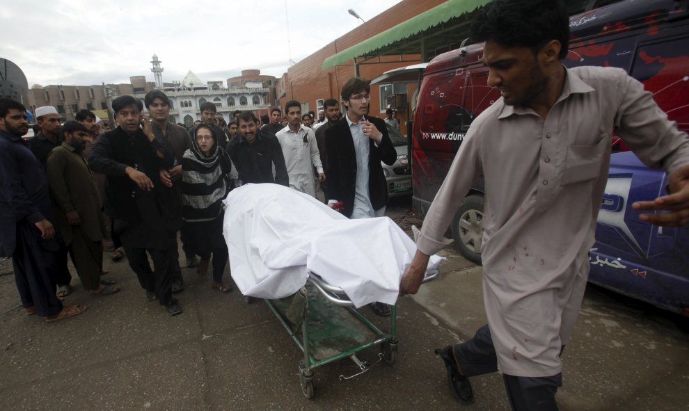 Un hombre traslada en una camilla a una de las mujeres fallecidas en  Peshawar (Pakistán) por el fuerte terremoto que ha golpeado la región. REUTERS/Fayaz Aziz