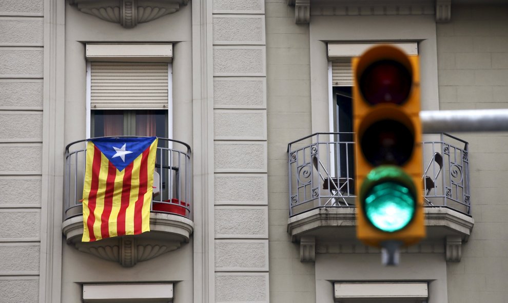 Una estelada catalana cuelga de un balcón en Barcelona al lado de un semáforo en verde. REUTERS/Albert Gea