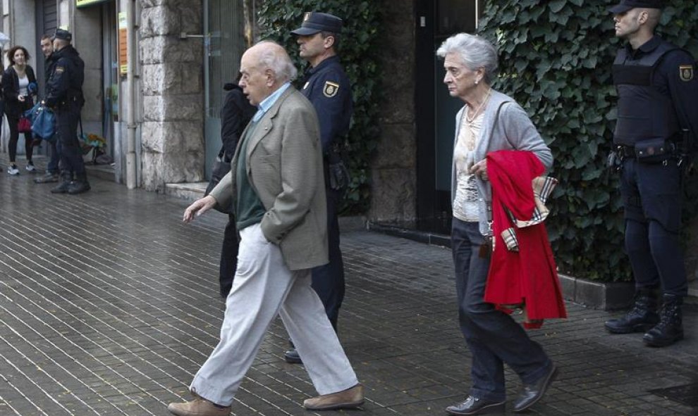 Jordi Pujol y su esposa, Marta Ferrusola, salen de su domicilio durante el registro de la UDEF. EFE/Quique García
