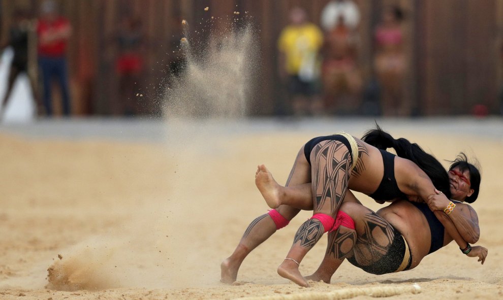 Dos mujeres indígenas de la tribu Kamayura participan en un combate de la modalidad Huka Huka durante los primeros Juegos Mundiales de Pueblos Indígenas en Palmas, Brasil.- REUTERS / Ueslei Marcelino