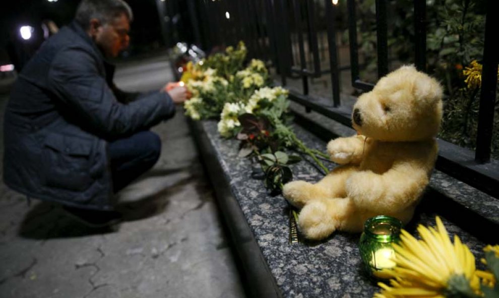 Solidaridad con las víctimas. Un hombre enciende una vela en memoria de las víctimas delante de la embajada de Rusia en Kiev. /  REUTERS (Valentyn Ogirenko)
