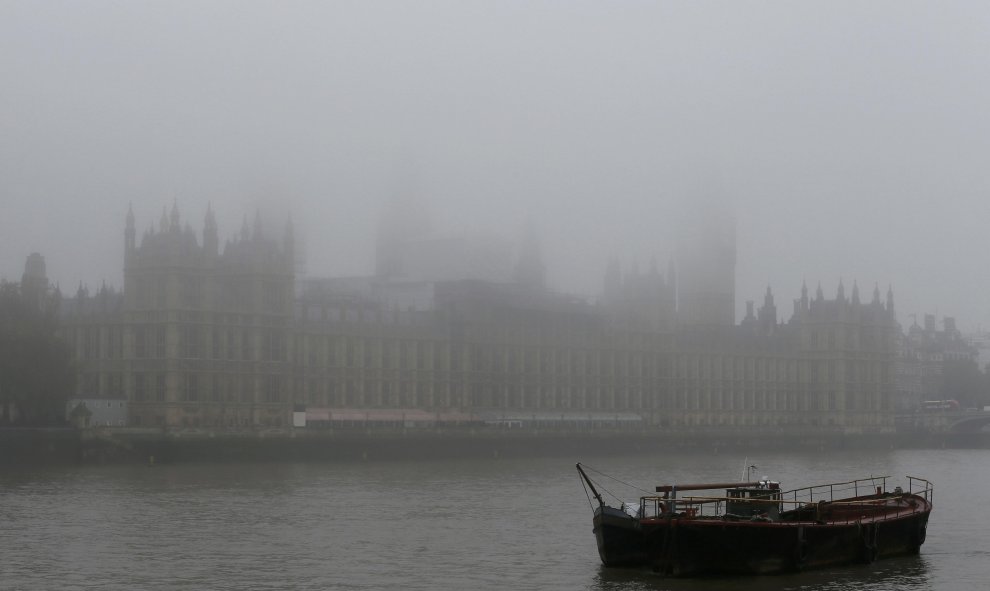 Un barco está amarrado en frente de la torre del reloj Big Ben y las Casas del Parlamento.- REUTERS.