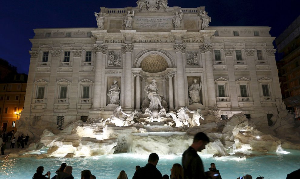 Un grupo de personas toman fotos durante la ceremonia de reapertura de la Fontana de Trevi en Roma, cerrada 16 meses durante su restauración. /REUTERS