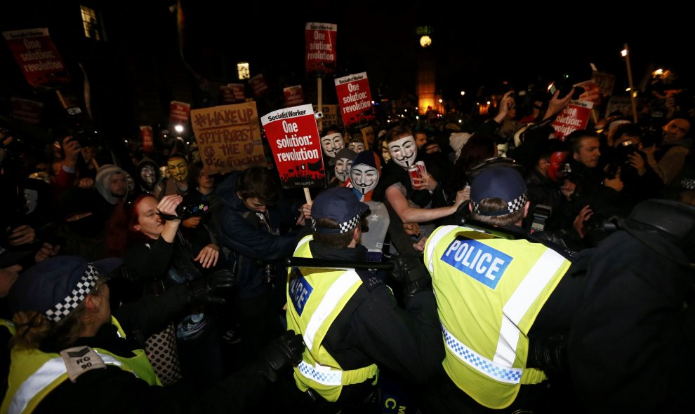 Los partidarios del grupo activista Anonymous plantan cara a la policía de  durante una protesta en Londres, Gran Bretaña 5 de noviembre de 2015. Miles de manifestantes participaron en la marcha 'Million Mask' en la capital el jueves . REUTERS / Stefan We