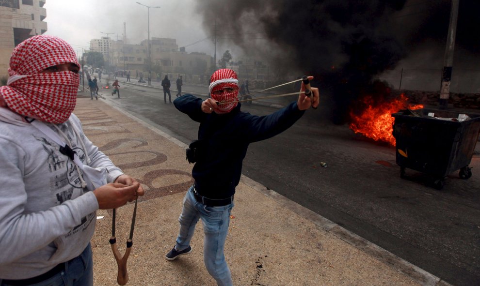 Manifestantes palestinos lanzan piedras a los soldados israelíes durante los enfrentamientos en Cisjordania. REUTERS/Abdelrahman Younis