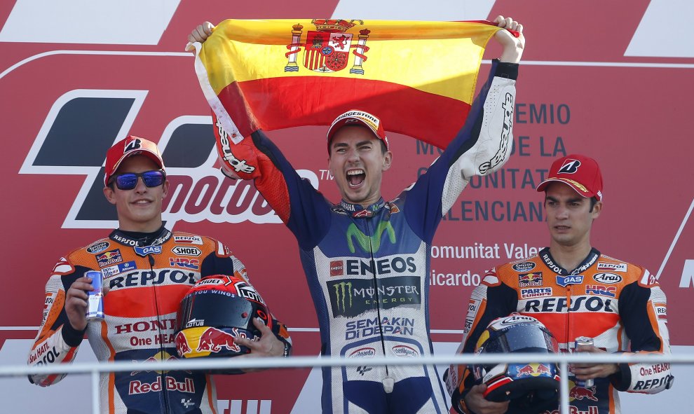 El piloto español Jorge Lorenzo (Yamaha ) en el podio junto a sus compatriotas Marc Márquez, segundo, y Dani Pedrosa, tercero, tras ganar la carrera y el mundial de Moto GP en el circuito "Ricardo Tormo" de Valencia. EFE/ Kai Forsterling