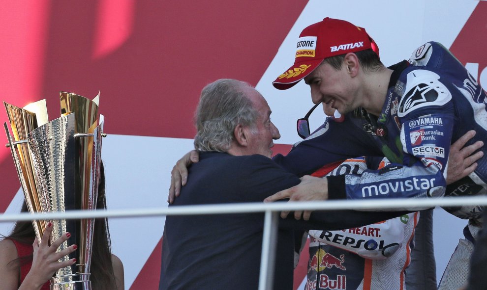 El rey Juan Carlos felicita en el podio al piloto español Jorge Lorenzo (Yamaha) por su nuevo título de campeón mundial de MotoGP tras imponerse hoy en el Gran Premio de la Comunidad Valenciana, último del campeonato, en el circuito "Ricardo Tormo" de Val