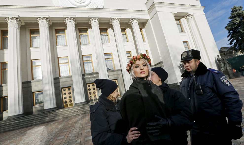 Un policía ucraniano arresta a una activista del movimiento Femen durante una protesta delante del Parlamento en Kiev (Ucrania) contra la homofobia y para reclamar que se corrija el Códido Laboral del país para prevenir y actuar contra la discriminación.