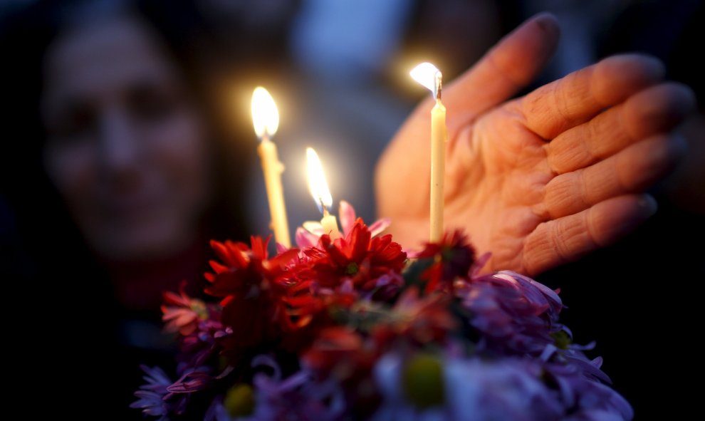 Una mujer sostiene flores y velas durante una procesión religiosa para conmemorar "El Día de 100.000 mártires" en Tbilisi, Georgia. REUTERS/David Mdzinarishvili