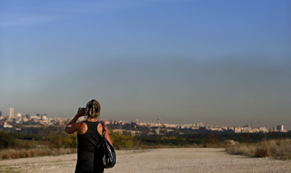 Una mujer hace una foto a la 'boina' de contaminación sobre Madrid debido a los altos niveles de dióxido de nitrógeno. EFE/Juan Carlos Hidalgo