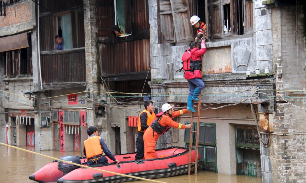 Los equipos de rescate tratan de slavar una mujer de un área inundada después de fuertes lluvias en Hezhou, China. REUTERS/Stringer
