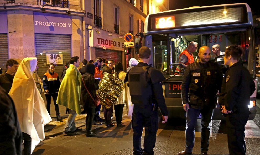 Agentes de policía franceses protegen a las víctimas de los atentados de París, perpetrados en la noche de este viernes. REUTERS