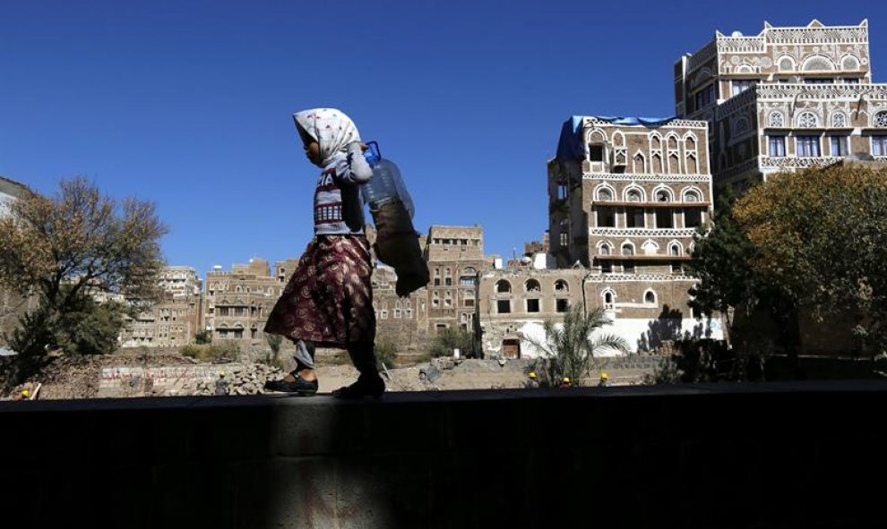 Una niña camina junto a edificios históricos destruidos por los bombardeos de la coalición árabe liderada por Arabia Saudí en Saná, Yemen. Las autoridades del país planean la reconstrucción de dos edificios destruidos el pasado 12 de junio. La Organizació