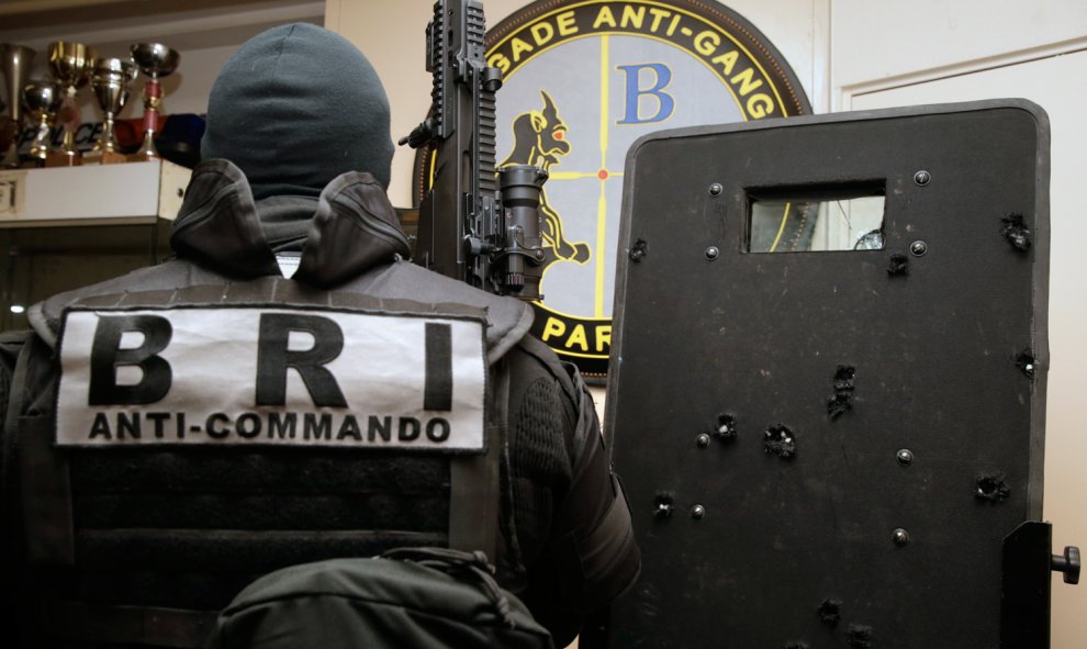 Agentes de la Policía y la Brigada de Intervención francesa (BRI) posan con el escudo, trufado de impactos de bala, que utilizaron para entrar en la sala Bataclan de París y liberar a los rehenes tomados por varios yihadistas.- AFP PHOTO / KENZO TRIBOUIL