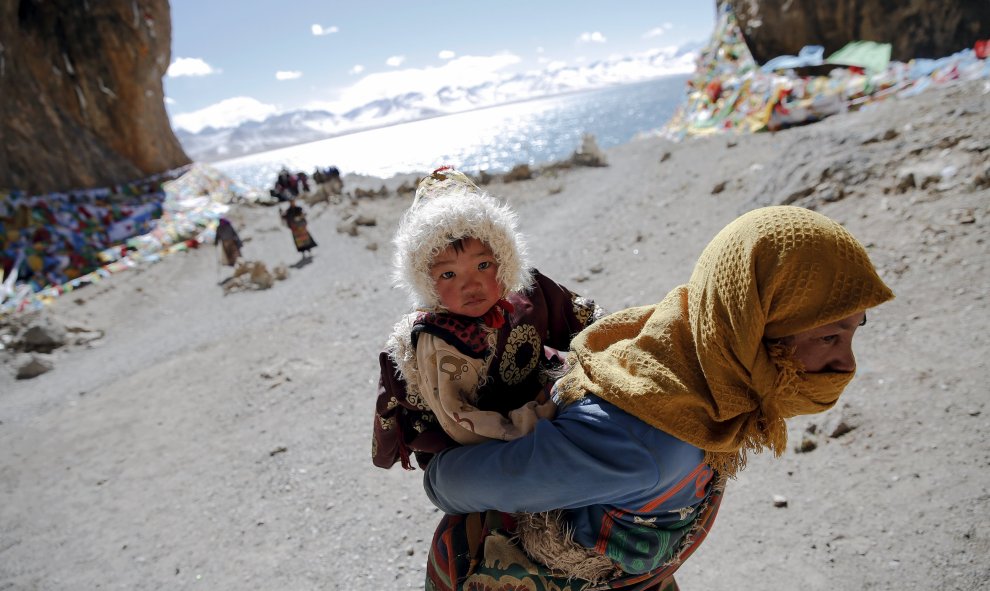 Una mujer tibetana lleva un niño en su visita a lago Namtso en la Región Autónoma del Tíbet , China 18 de noviembre de 2015. REUTERS / Damir Sagolj