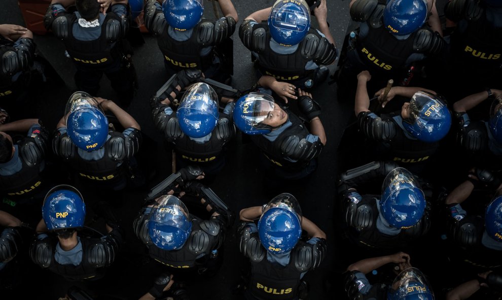 Un policía de Filipinas mira hacia arriba tras una manifestación en contra de la (APEC) Cumbre de Cooperación Económica Asia-Pacífico en Manila el 19 de noviembre de 2015. AFP/PHILIPPE LOPEZ