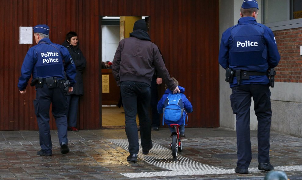 Varios niños entran al colegio bajo la mirada de la policía. REUTERS/Yves Herman