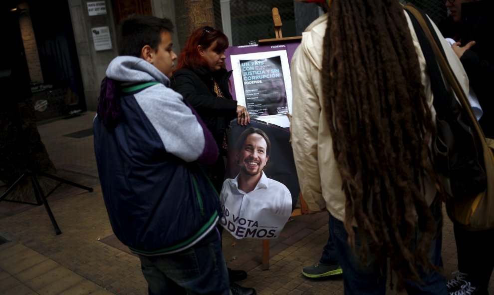 Seguidores de Podemos en Málaga, sostienen un cartel electoral de Pablo Iglesias. REUTERS/Jon Nazca