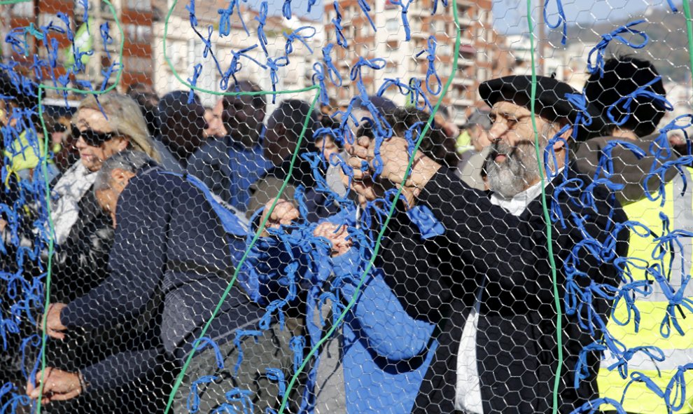 Militantes de la izquierda abertzale colocan lazos en favor de la independencia durante la manifestación que ha recorrido las calles de Bilbao en contra de la Constitución española, coincidiendo con la celebración de su aniversario, y en demanda de una re