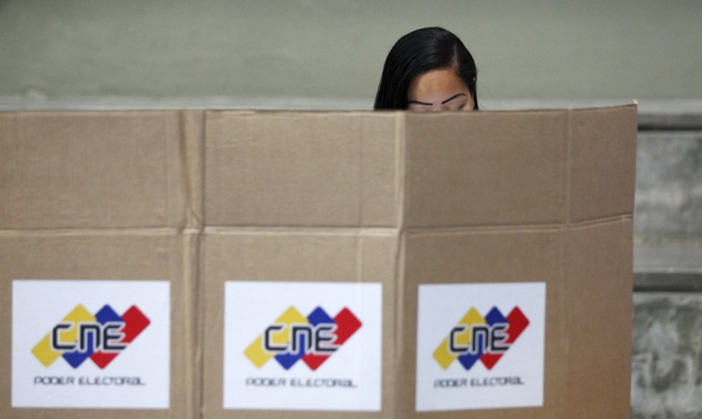 Una mujer vota en secreto en Caracas, Venezuela. REUTERS/Christian Veron