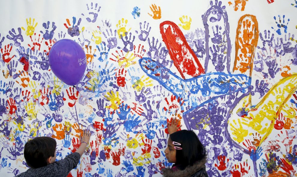 Niños pintando en un muran en el acto de Podemos en Madrid, junto al Museo Reina Sofía, en el que ha intervenido el líder del partido Pablo Iglesias. REUTERS/Susana Vera