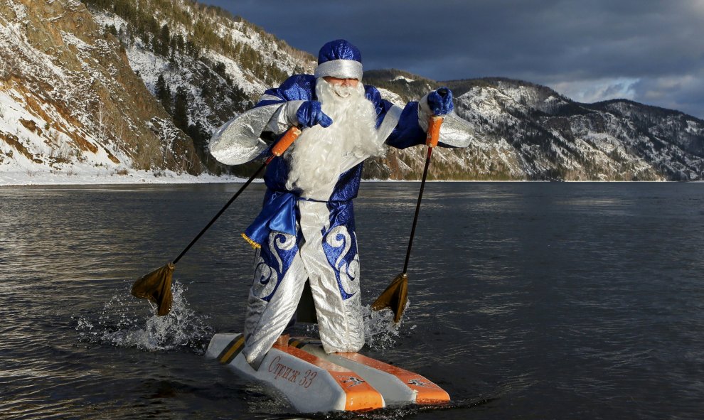 Nikolai Vasilyev, de 62 años, vestido como Papá Noël, el equivalente ruso de Santa Claus, hace esquí acuático a lo largo del río Yenisei fuera de la ciudad siberiana de Krasnoyarsk, Rusia, 10 de diciembre de 2015. REUTERS / Ilya Naymushin