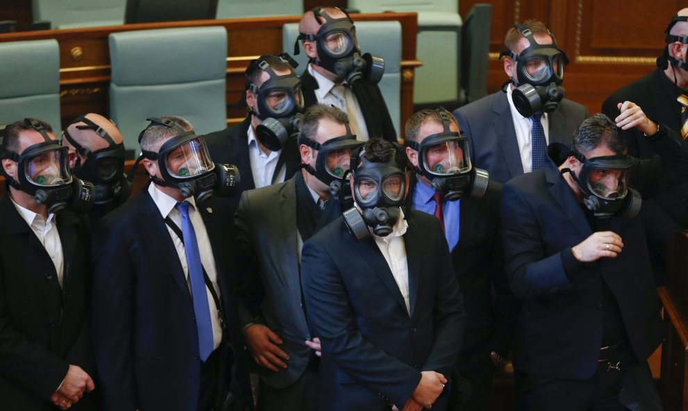 Diputados utilizan máscaras antigás después de que miembros de la oposición lanzaran gas lacrimógeno durante una sesión parlamentaria en Pristina, Kosovo. EFE/Valdrin Xhemaj