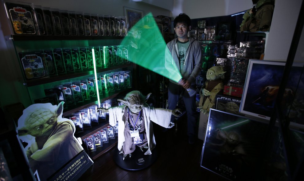 Le llaman Tsukikage, tiene 42 años, vive en Kawasaki, al sur de Tokio, y se dedica a coleccionar artículos relacionados con Yoda, su personaje favorito de la saga. En la foto, Tsukikage posa con su espada laser. REUTERS / Issei Kato