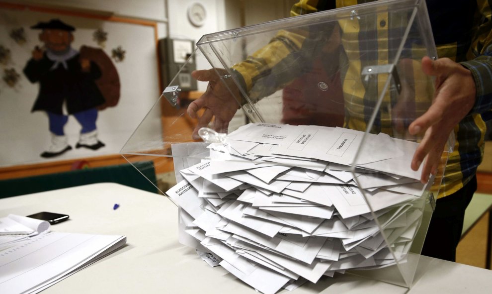 El presidente de una mesa electoral deposita los votos de la urna sobre una mesa para proceder a su recuento./EFE/Jesús Diges