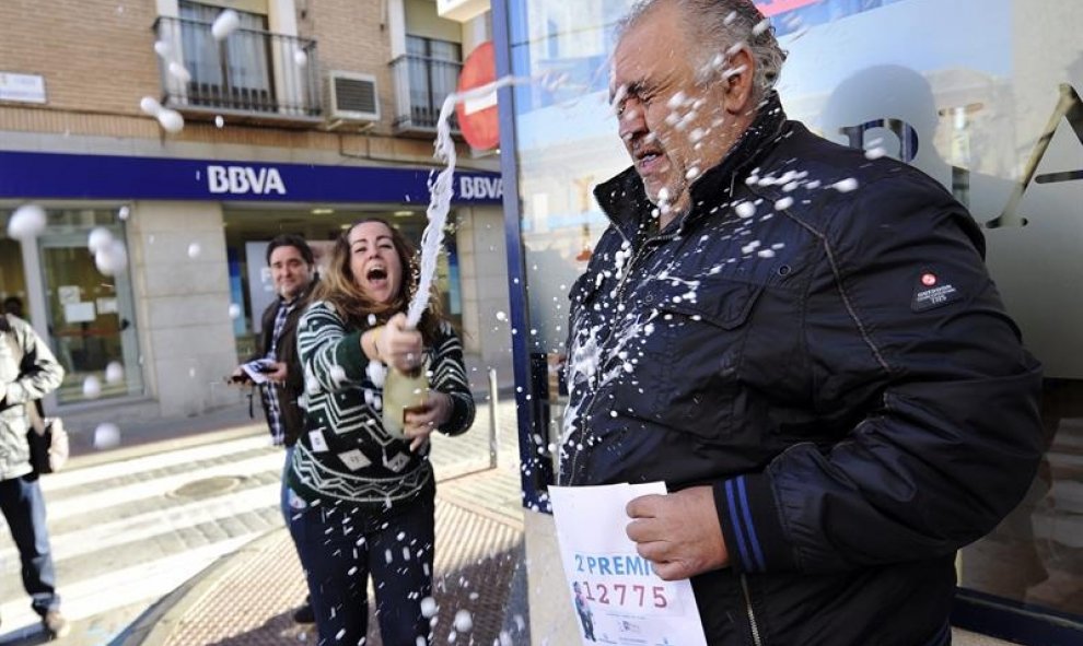 Un lotero celebra que ha vendido una serie del segundo premio del Sorteo de Navidad, el 12.775, con lo que ha repartido un total de 1.250.000 euros. EFE/Ismael Herrero