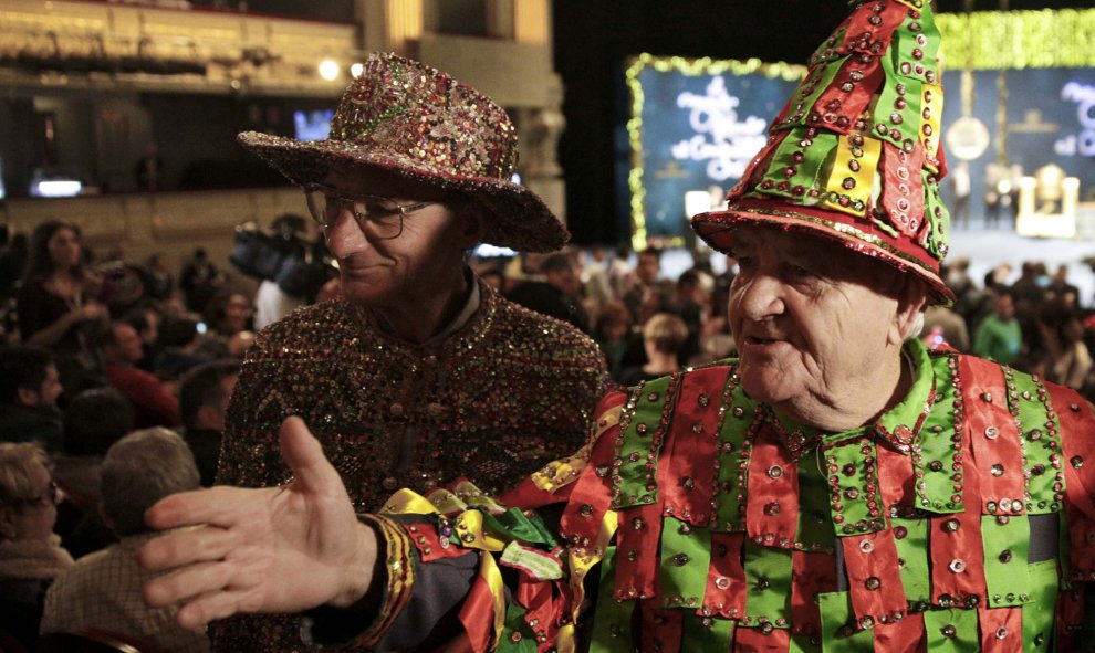 Dos hombres disfrazados, en el Teatro Real, con el Sorteo de Navidad de fondo. REUTERS/Andrea Comas
