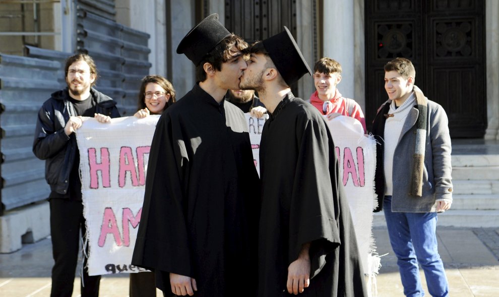 Activistas por los derechos de los homosexuales disfrazados de sacerdotes ortodoxos griegos se besan durante una protesta contra la homofobia junto a la catedral de Atenas. REUTERS/Michalis Karagiannis