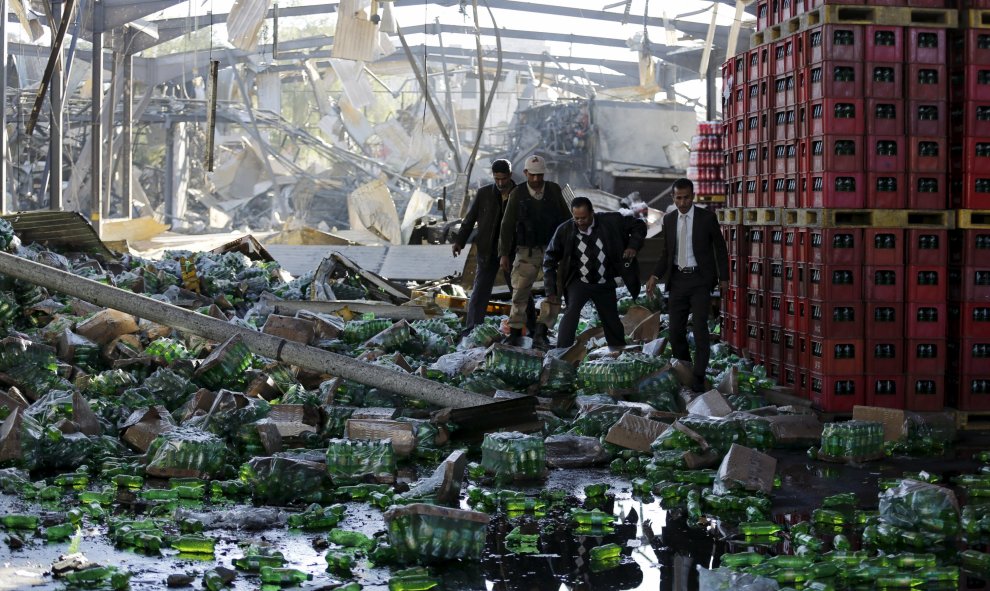 Varios funcionarios inspeccionan los daños producidos en una fábrica de Coca-Cola causados por los ataques aéreos liderados por Arabia que cayeron en la capital de Yemen, Saná, 30 de diciembre de 2015. REUTERS / Khaled Abdullah
