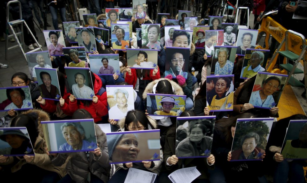 Estudiantes sostienen retratos de antiguas "mujeres confort" ya fallecidas, en una manifestación semanal anti-Japón frente a la embajada japonesa en Seúl, Corea del Sur, 30 de diciembre de 2015. REUTERS / Kim Hong - Ji