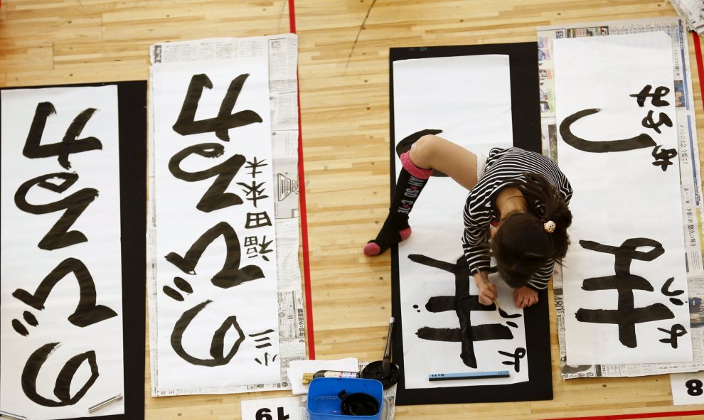 Una niña participa en un concurso de caligrafía para celebrar el Año Nuevo en Tokio. REUTERS/Thomas Peter