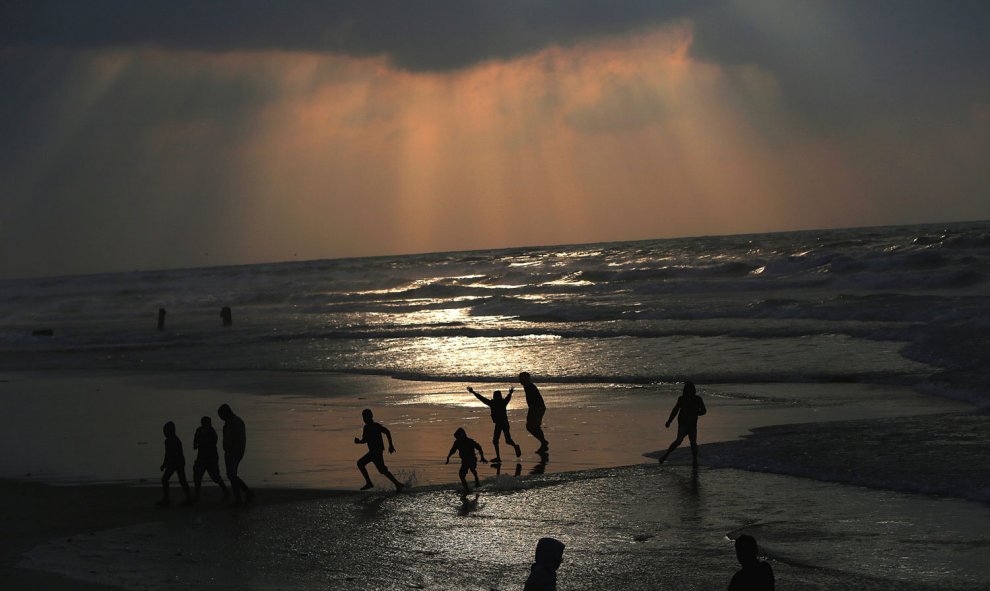 Jóvenes palestinos pasan la tarde en la playa de Gaza durante una puesta de sol, el 3 de enero de 2016.- EFE/EPA/MOHAMMED SABER