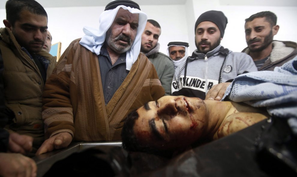 Familiares y médicos observan el cuerpo de Ahmad Kawazbeh, de 17 años, en un hospital de la ciudad cisjordana de Hebrón, Palestina, el 5 de enero de 2016. Kawazbeh fue asesinado por las fuerzas de seguridad israelíes después de que intentara apuñalar a un