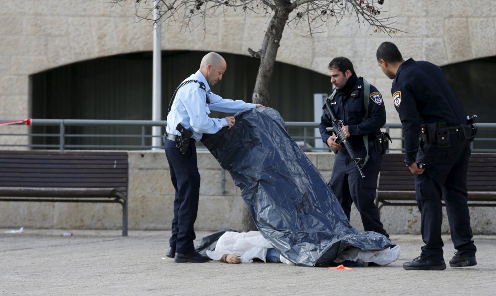 Policías israelíes junto al cadáver de un palestino que fue asesinado a tiros después de intentar de apuñalar a un oficial, según un portavoz de la Policía, cerca Ciudad Vieja de Jerusalén. 26 de diciembre de 2015. REUTERS / Ammar Awad