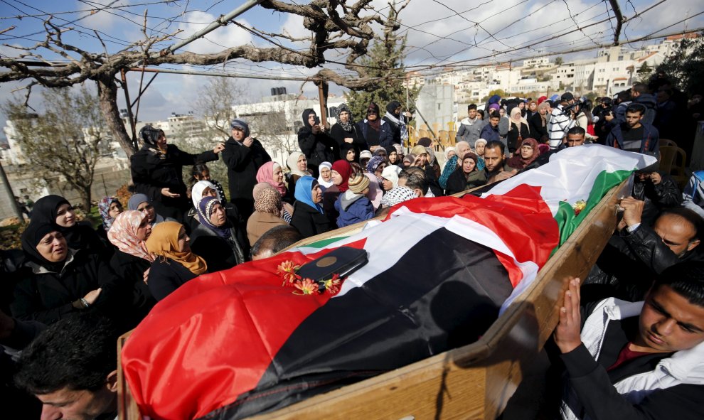 Los dolientes llevan el cuerpo de la palestina Mahdia Hamad, de 38 años, durante su funeral en Silwad cerca de la ciudad cisjordana de Ramala, el 26 de diciembre de 2015. Los policías fronterizos israelíes mataron a Hamad después de que que intentara embe