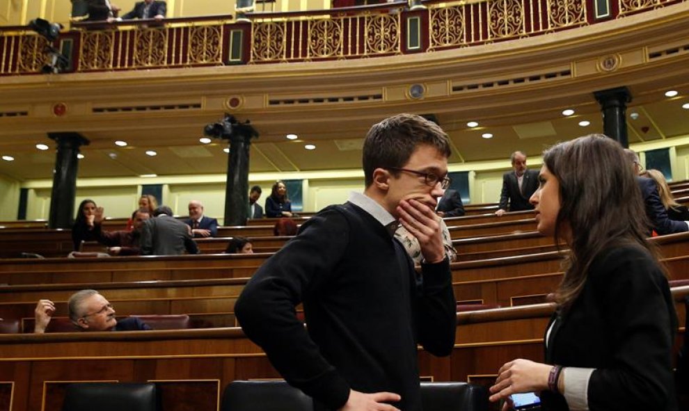 Los diputados de Podemos Iñigo Errejón e Irene Montero conversan en el hemiciclo del Congreso.- EFE