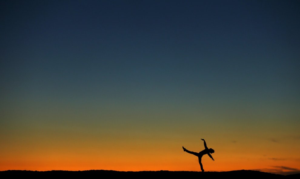 El ex bailarín Lucas Willis actúa en la arena delante de la puesta del sol en Encinitas, California. REUTERS / Mike Blake