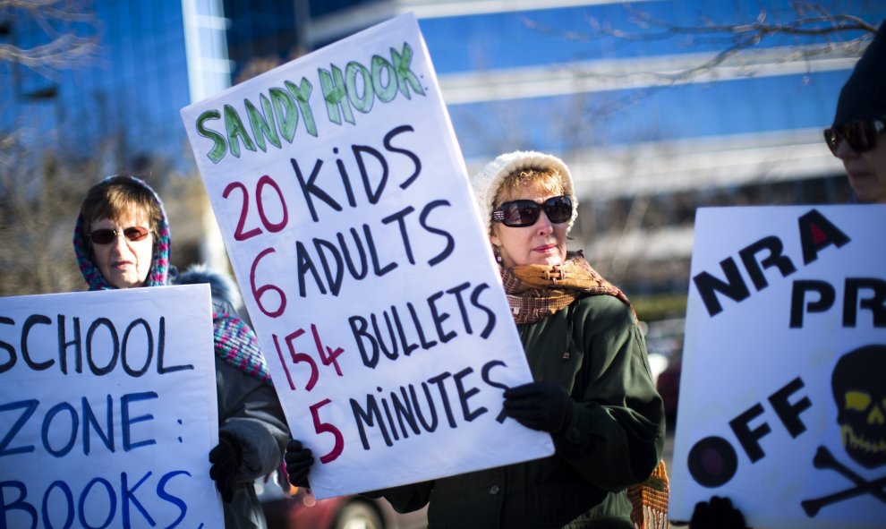 Decenas de personas se manifiestan frente a la sede de la Asociación Nacional del Rifle (NRA) para pedir un mayor control sobre la venta de armas en Fairfax, Virginia, Estados Unidos, hoy 14 de enero de 2016. EFE/Jim Lo Scalzo