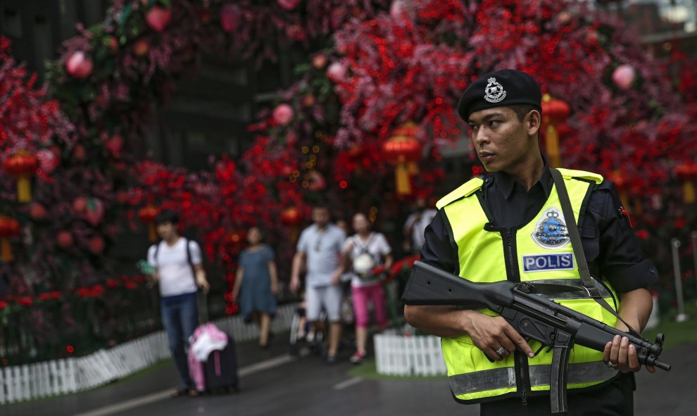 Miembros de la policía malaya hacen guardia en el exterior de un centro comercial en Kuala Lumpur, Malasia, hoy 20 de enero de 2016. Según informaron fuentes oficiales, las autoridades de Malasia reforzaron la seguridad y los controles como medida de prec